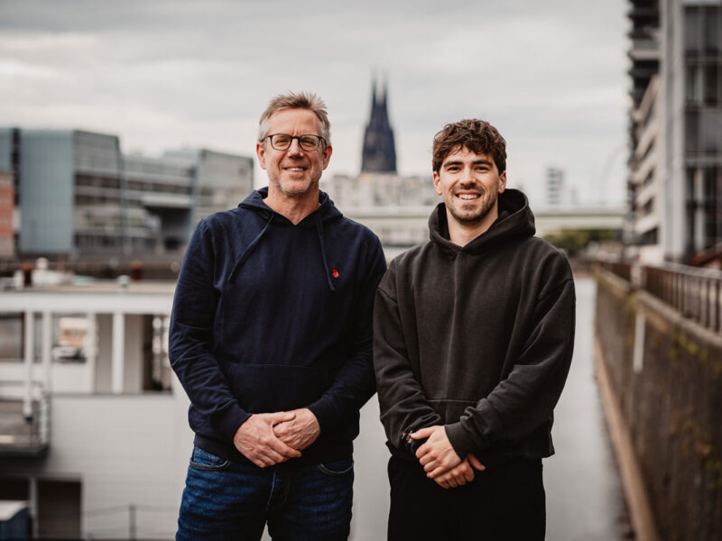 Stephan Schroeder und Tim Dichiser vor der Kölner Skyline, Dom im Hintergrund